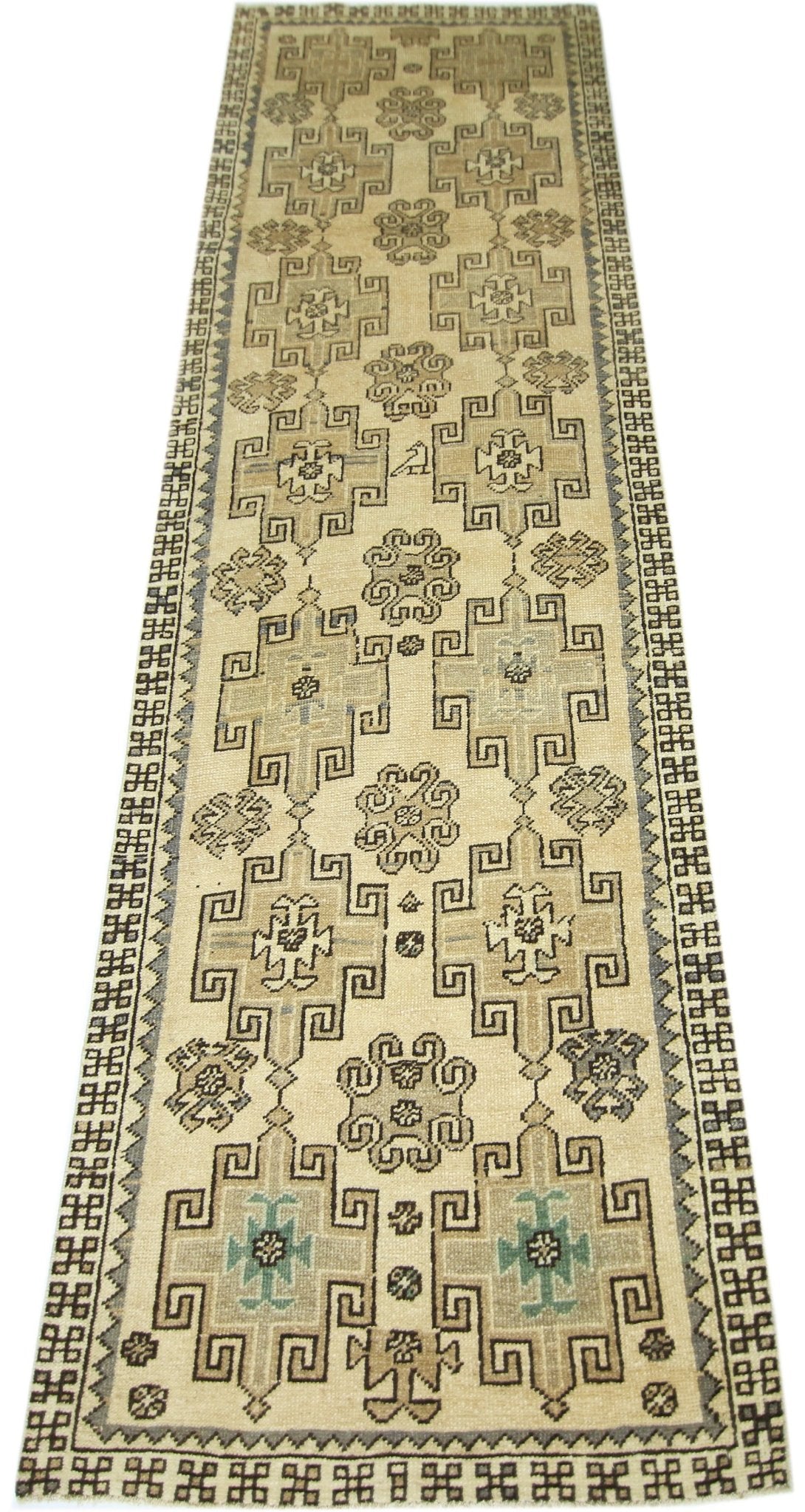 A vintage Turkish Anatolian runner featuring geometric patterns in neutral tones on a cream field.