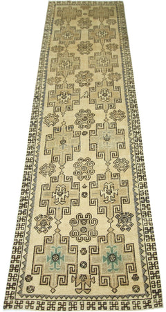 A vintage Turkish Anatolian runner featuring geometric patterns in neutral tones on a cream field.