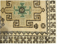 A vintage Turkish Anatolian runner featuring a geometric pattern in beige, green, and brown.