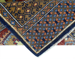 A vintage handmade wool runner featuring a geometric Bokhara pattern in blue, brown, and orange.