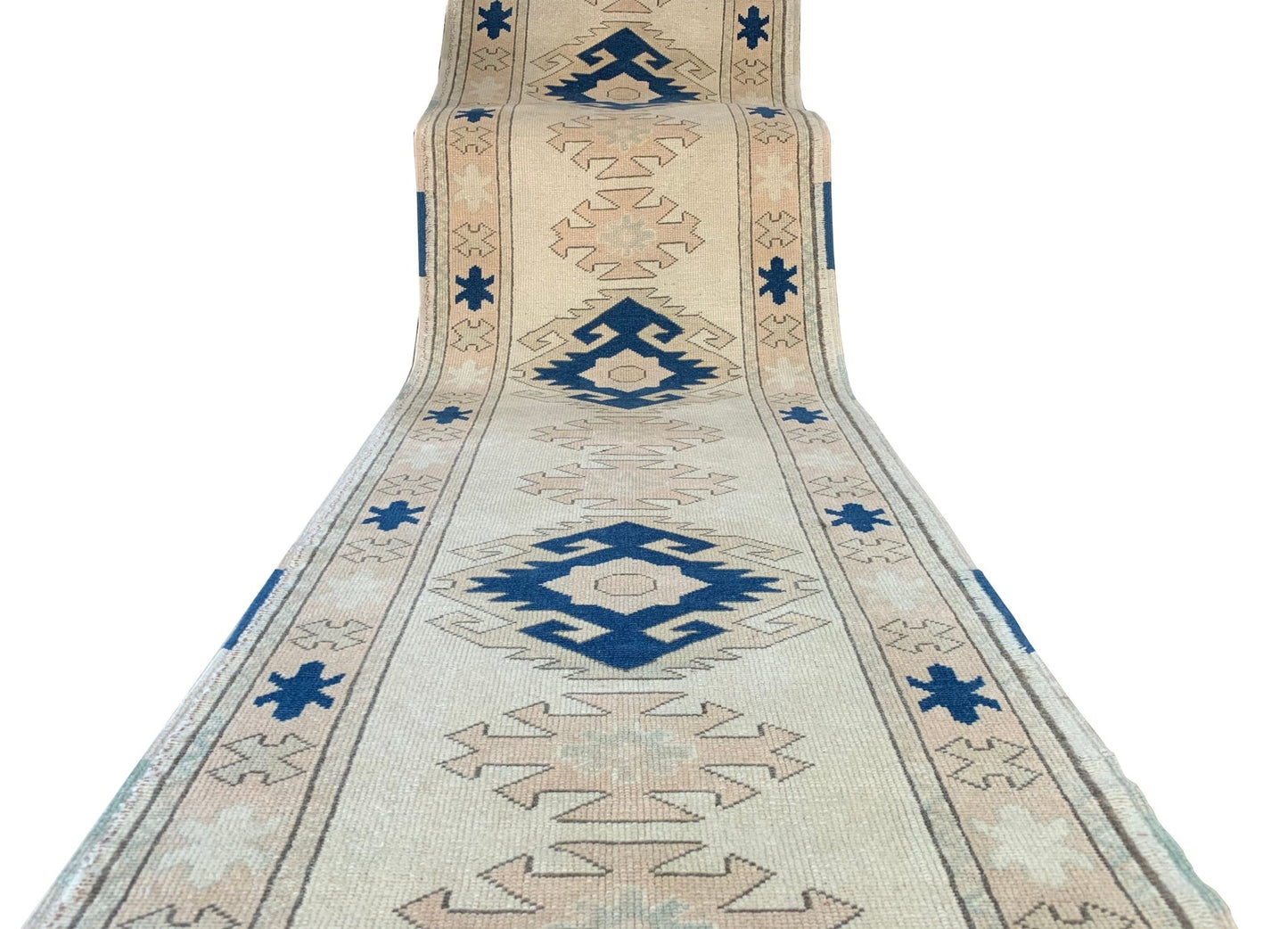 A vintage Turkish Oushak runner featuring tribal blue and beige geometric motifs on a wool base.