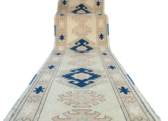 A vintage Turkish Oushak runner featuring tribal blue and beige geometric motifs on a wool base.