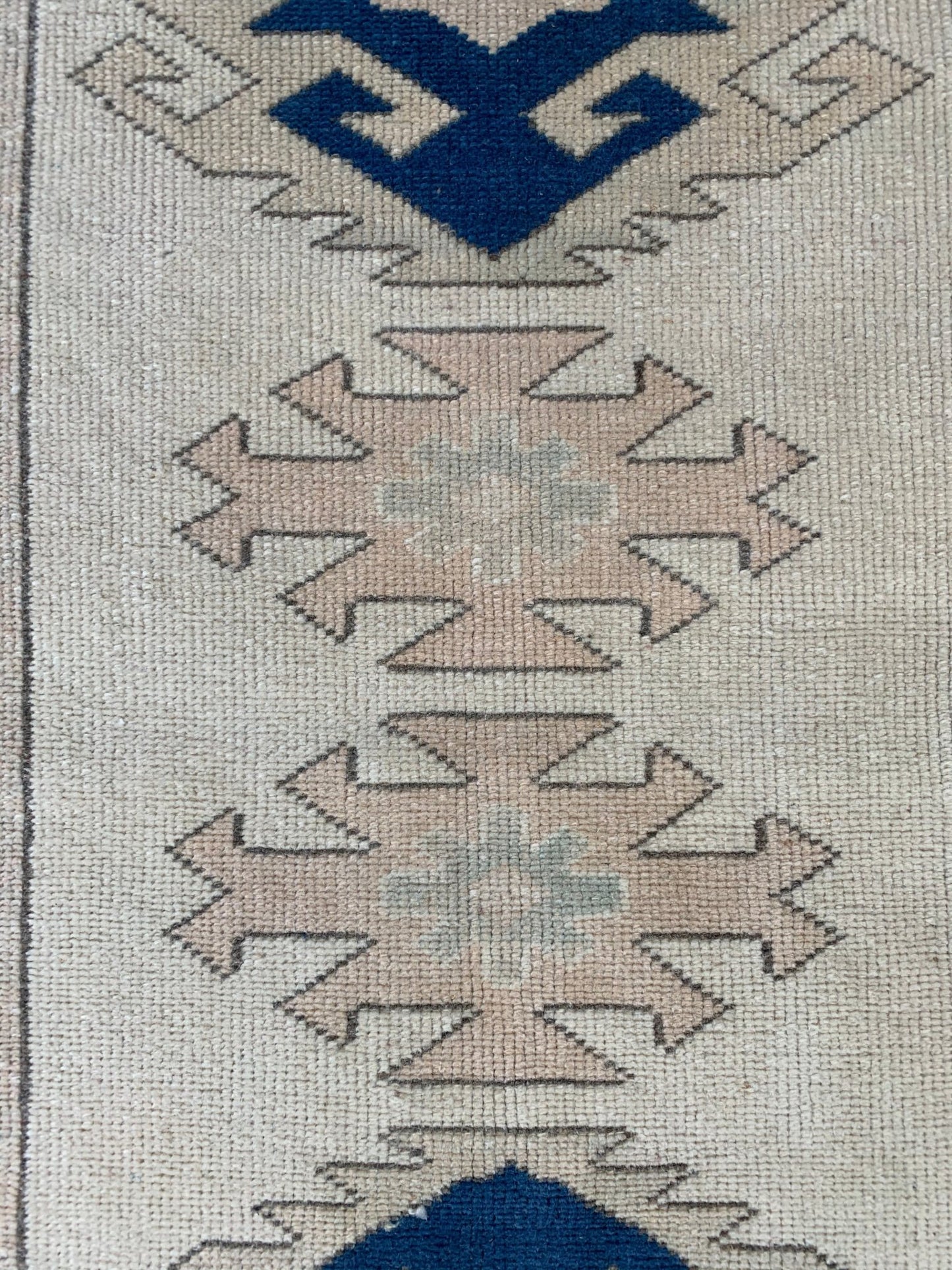 A vintage Turkish Oushak runner featuring tribal Seljuk motifs in blue and beige wool.