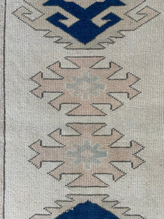 A vintage Turkish Oushak runner featuring tribal Seljuk motifs in blue and beige wool.