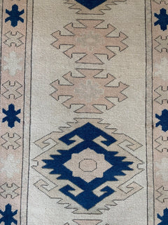 A vintage Turkish Oushak runner featuring tribal Seljuk motifs in blue and beige wool.