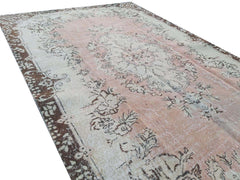 A vintage handmade Turkish Isparta rug featuring a floral pattern in soft pink and brown tones.