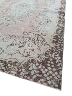A vintage handmade Turkish Isparta rug featuring a soft floral center and a dark patterned border.