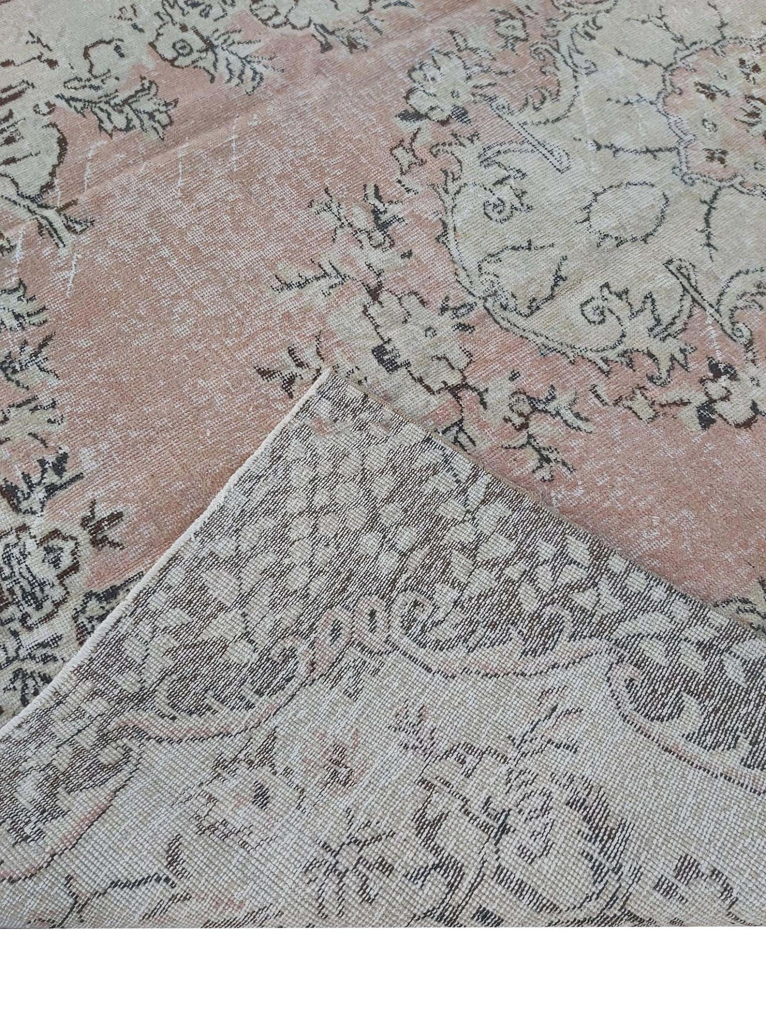 A vintage handmade Turkish Isparta rug featuring a floral pattern in soft pink and neutral tones.