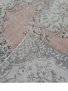 A vintage handmade Turkish Isparta rug featuring a floral pattern in soft pink and neutral tones.