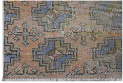 A vintage Turkish Isparta runner featuring a geometric pattern in orange, blue, and muted tones.