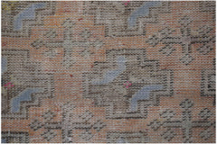A vintage Turkish Isparta runner featuring a geometric pattern in faded orange, blue, and grey.
