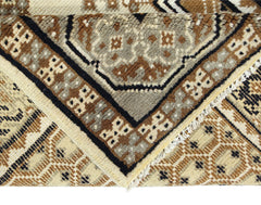 A handwoven Afghan rug featuring geometric tribal motifs in shades of brown and cream.