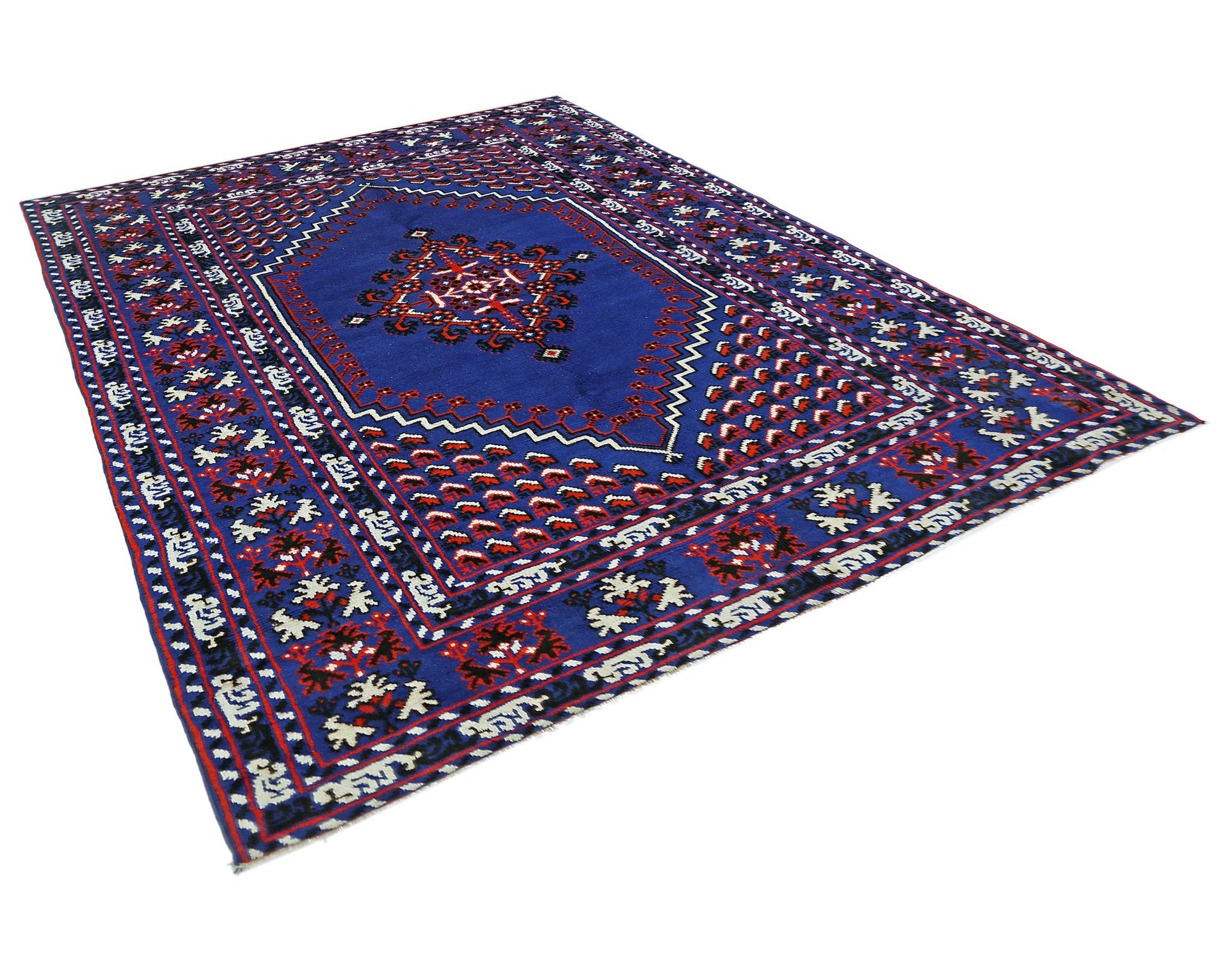 A handmade vintage Turkish rug featuring a deep blue field with intricate red and white geometric patterns.