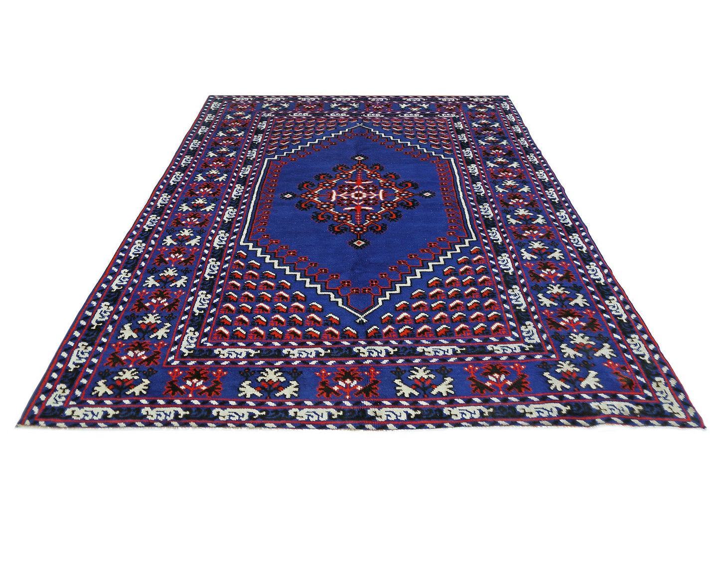 A vintage handmade Turkish rug featuring a central medallion on a deep blue field with red accents.