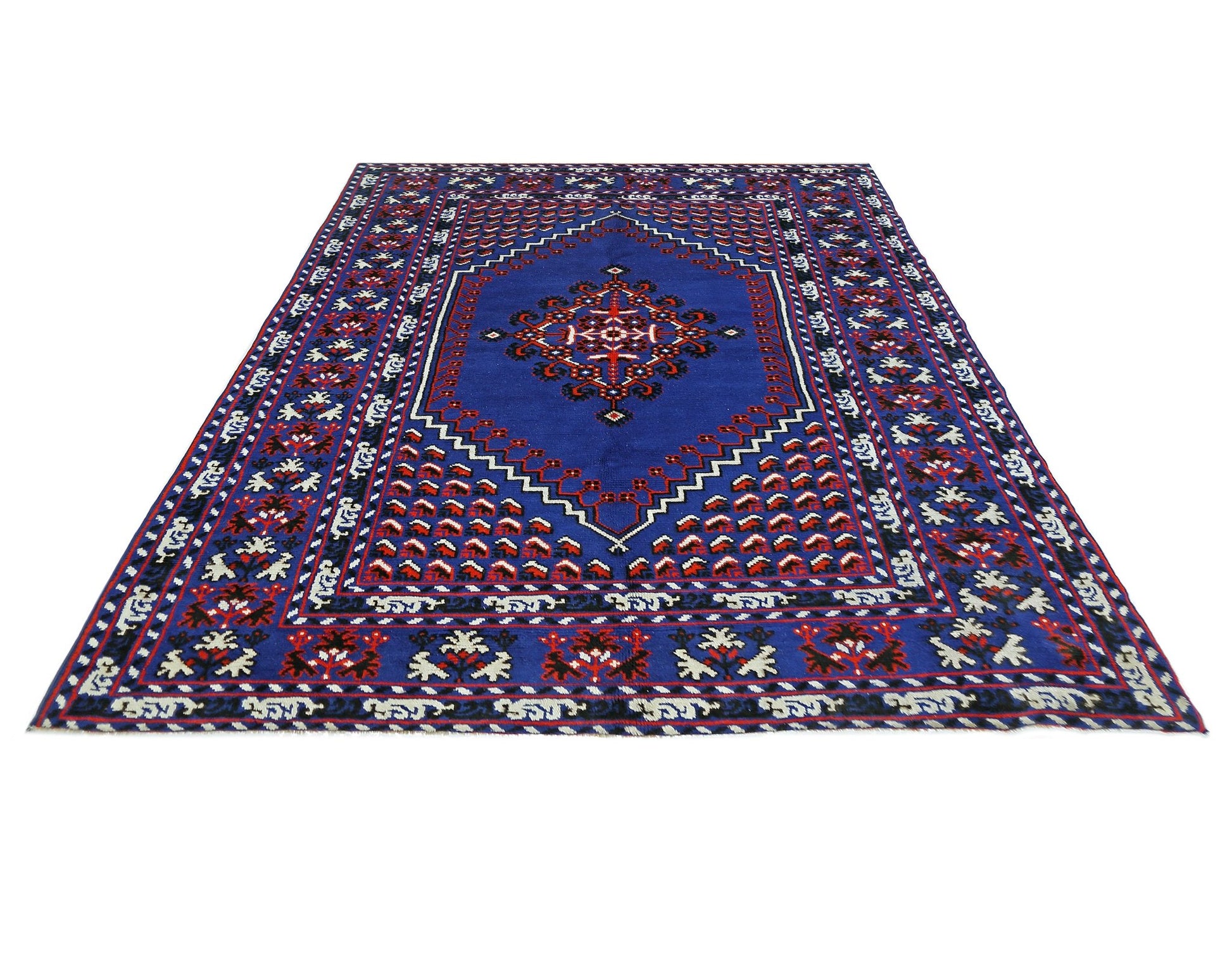 A vintage handmade Turkish rug featuring a central medallion on a deep blue field with red accents.