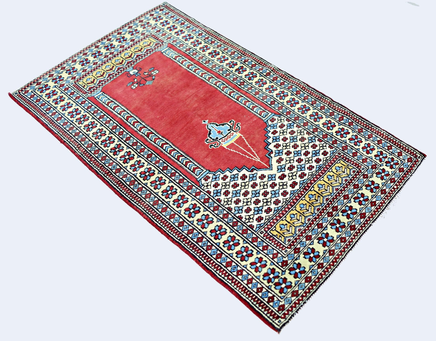 A vintage handmade Turkish Kayseri rug featuring a red prayer niche with intricate floral motifs.