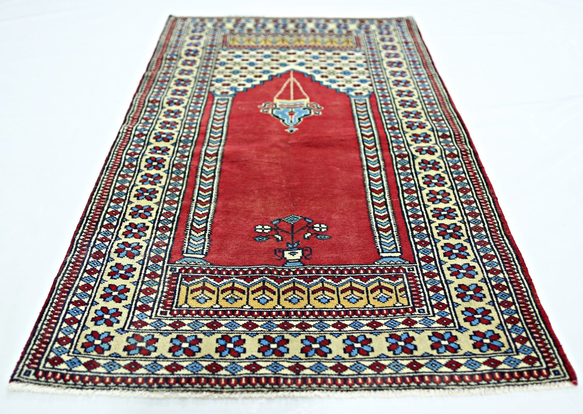 A handmade vintage Turkish Kayseri prayer rug featuring a red field with floral and lamp motifs.