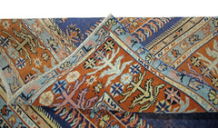 A folded vintage Persian prayer rug featuring intricate geometric patterns in orange and blue.