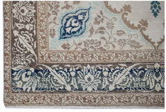 A vintage handwoven Turkish rug featuring intricate floral patterns in blue, brown, and cream.