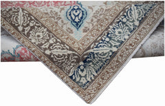 A handwoven vintage Turkish rug featuring a floral pattern in blue, brown, and cream tones.