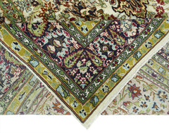 A vintage Turkish Kayseri rug featuring intricate floral patterns in green, red, and cream tones.