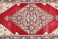 Vintage Turkish runner with a red field and a central diamond medallion.