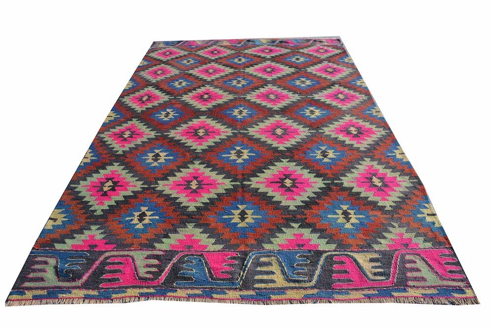 A vintage handmade Turkish kilim rug featuring a repeating diamond pattern in neon and earth tones.