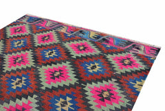 A vintage Turkish kilim rug featuring a geometric diamond pattern in vibrant neon and earthy tones.