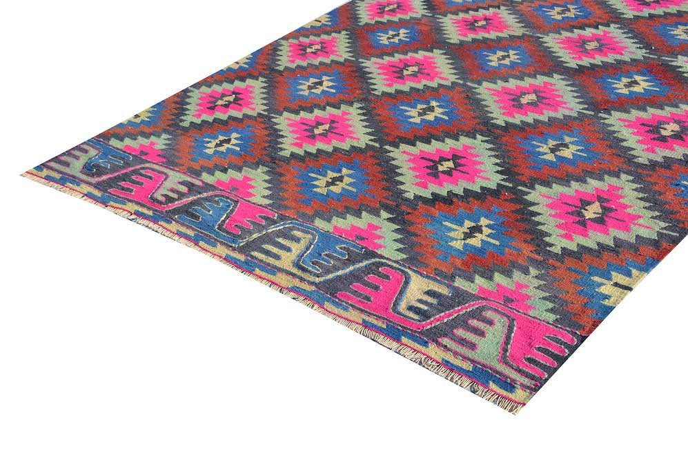 A handmade vintage Turkish kilim rug featuring a geometric diamond pattern in neon and earth tones.