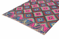 A handmade vintage Turkish kilim rug featuring a geometric diamond pattern in neon and earth tones.