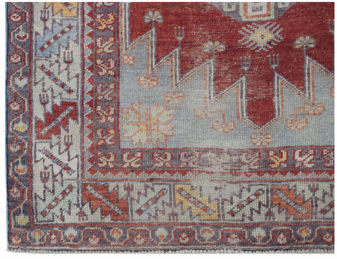 A vintage Turkish Kula rug featuring geometric patterns in red, blue, and yellow wool.