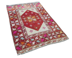 A vintage handmade Turkish Kula rug featuring a red diamond medallion and colorful geometric motifs.