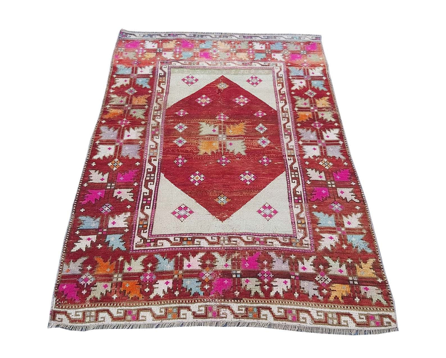 A vintage Turkish Kula rug featuring a red diamond medallion on a cream field with geometric motifs.