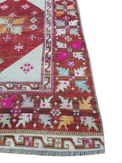 A vintage Turkish Kula rug featuring geometric patterns in a vibrant, multi-colored wool design.