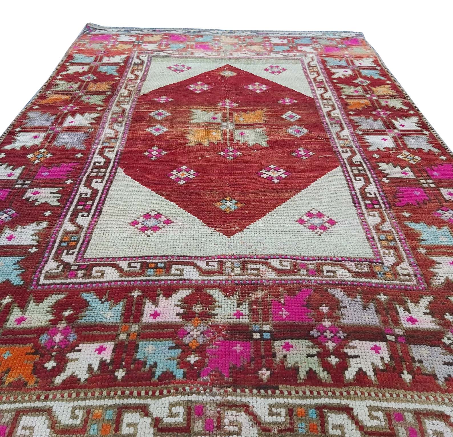 A vintage handmade Turkish Kula rug featuring a central red diamond and geometric patterns.