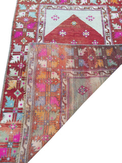 A vintage handmade Turkish Kula rug featuring geometric patterns in vibrant colors.