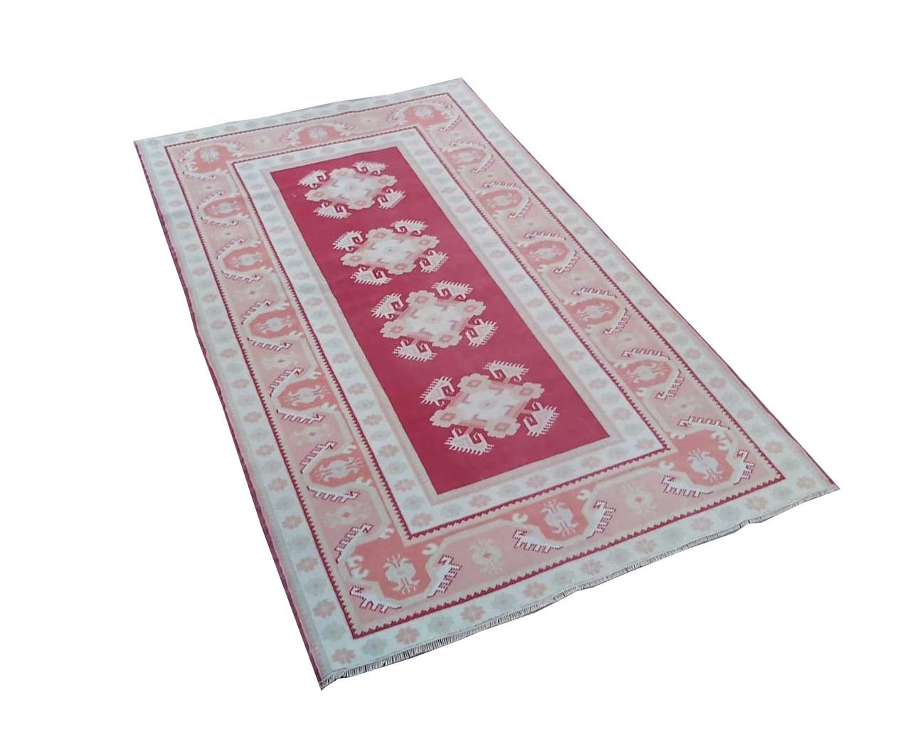A vintage Turkish Milas rug featuring a red field with geometric motifs and a light border.