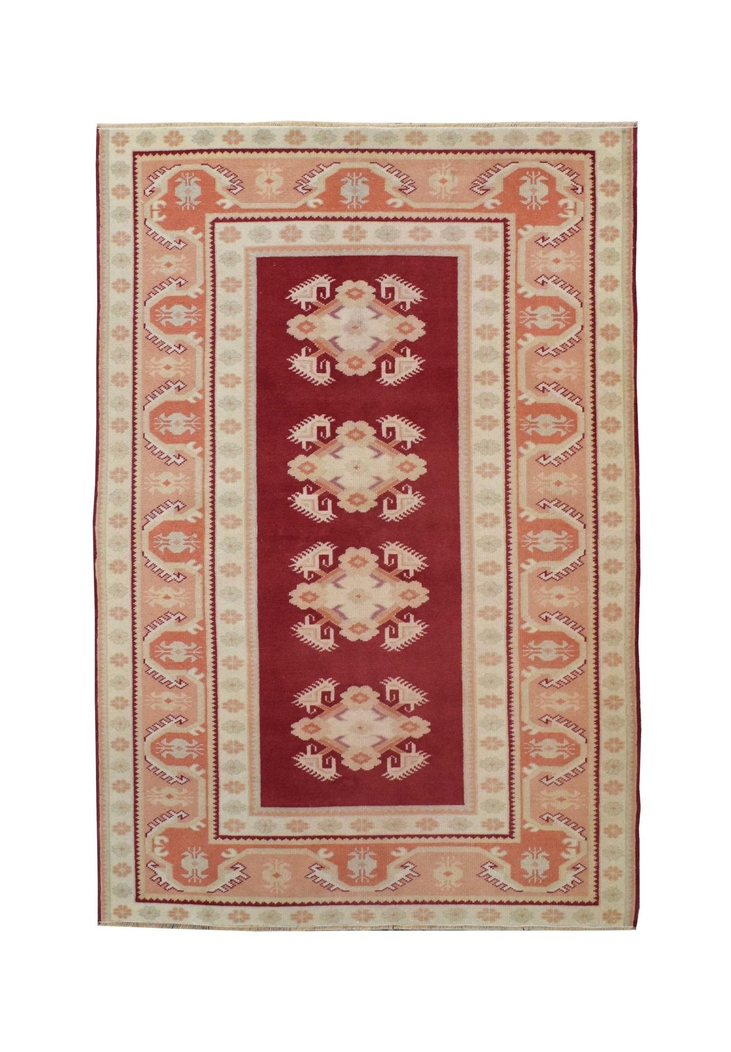A vintage Turkish Milas rug featuring a deep red field with four geometric medallions.