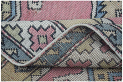 Vintage Turkish Milas rug with pink, blue, and cream geometric patterns.