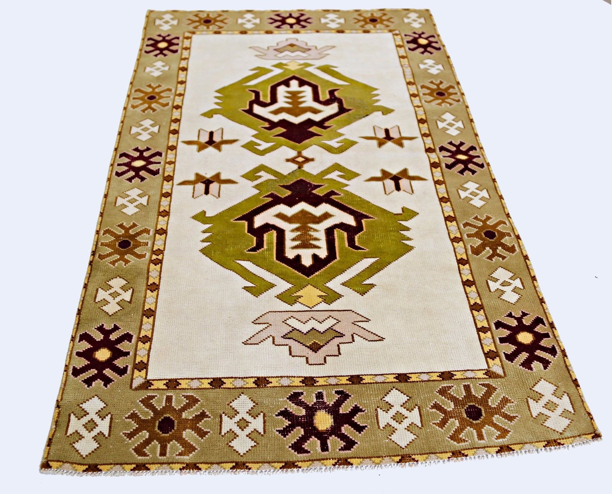 A vintage handmade Turkish Milas rug featuring geometric patterns in olive green and brown tones.