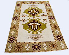 A vintage handmade Turkish Milas rug featuring geometric patterns in olive green and brown tones.