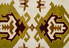 A vintage Turkish Milas rug featuring a geometric pattern in olive green, brown, and cream.