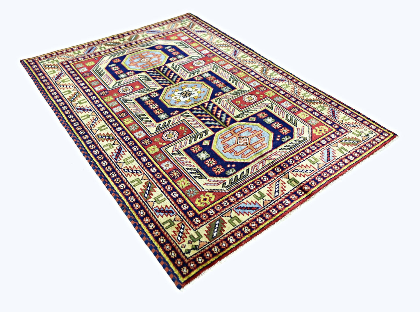 A rectangular vintage Turkish rug featuring geometric patterns in red, blue, and cream tones.
