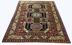 A handmade vintage Turkish wool rug featuring a geometric pattern in blue, red, and cream tones.
