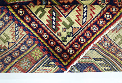 A folded vintage Turkish rug featuring intricate geometric patterns in vibrant red, blue, and green.