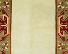 A vintage Turkish Milas rug featuring a cream central field framed by ornate red and brown borders.