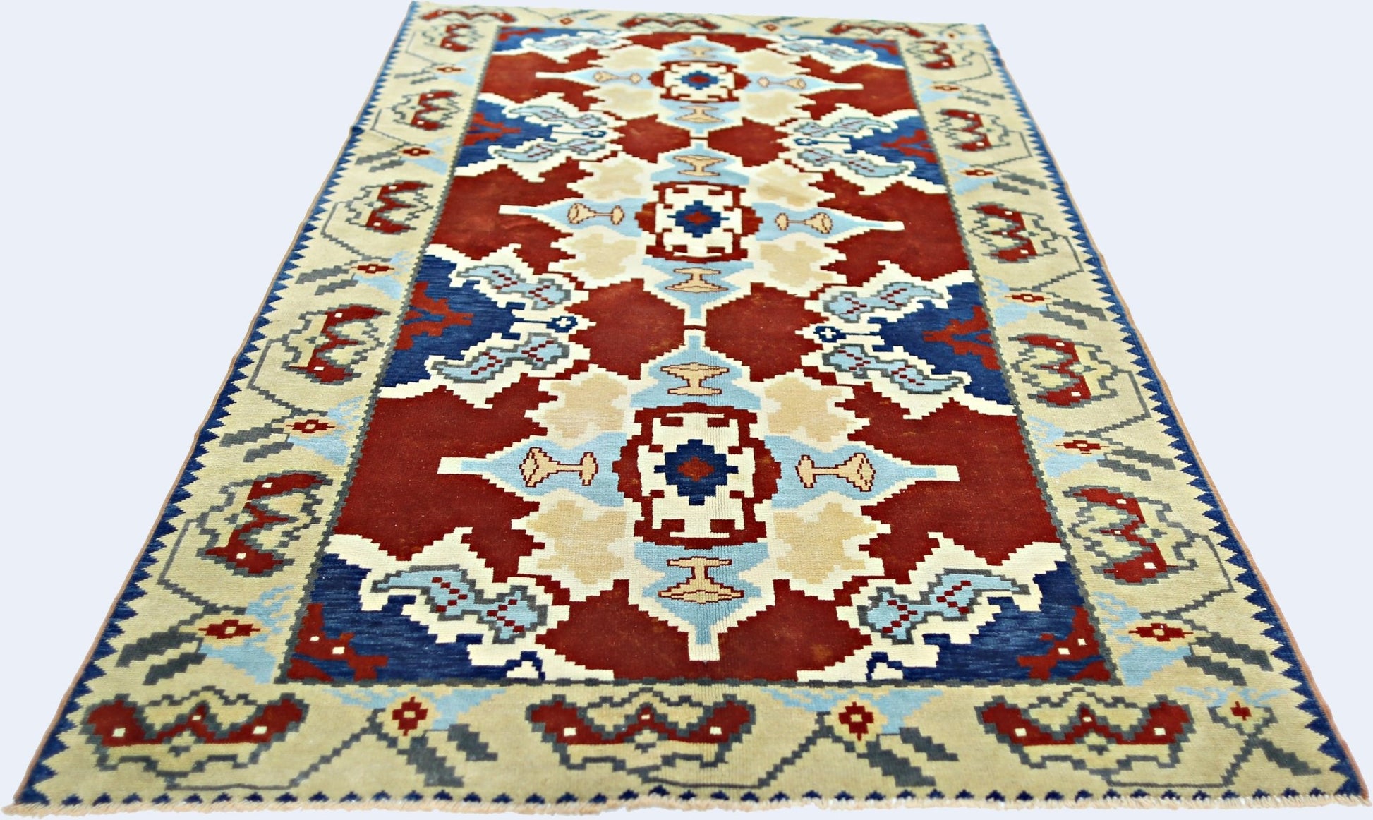 A handmade vintage Turkish rug featuring a geometric pattern in red, blue, and cream tones.
