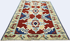 A handmade vintage Turkish rug featuring a geometric pattern in red, blue, and cream tones.