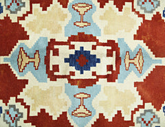 A vintage Turkish rug featuring a geometric pattern in shades of red, blue, and cream.