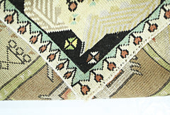 A close-up view of a vintage Turkish runner showing its intricate geometric pattern and wool weave.